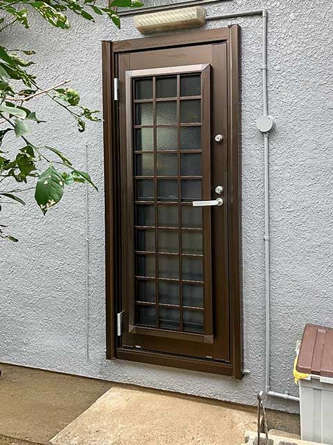 外壁に馴染むブラウンカラーの断熱仕様の勝手口ドア（屋外側）