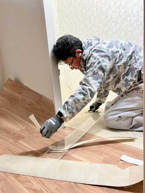 フローリング貼り作業中の職人。手作業で仕上げる。