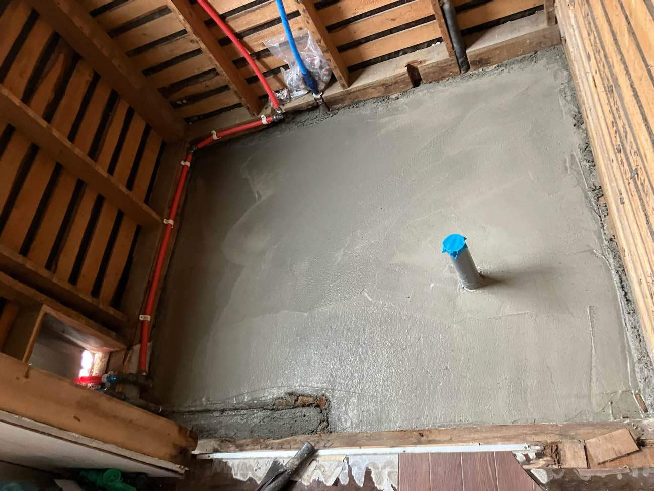 柏市I様邸の浴室リフォーム施工中。ユニットバスを据え付ける前の土間コンクリートとモルタルで平らに仕上げた防水下地