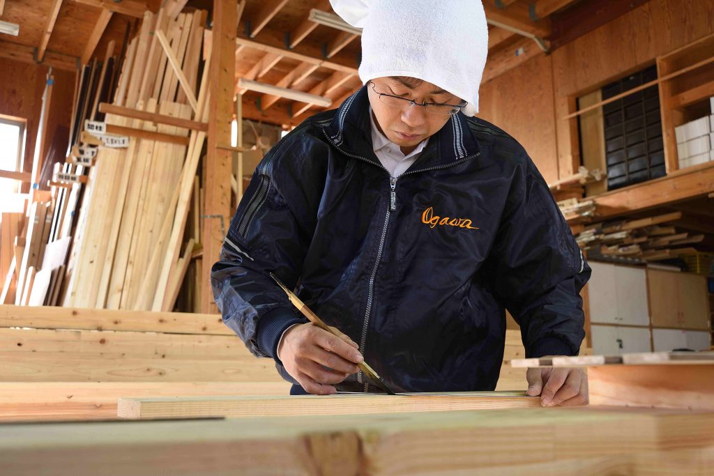 小川工務店の大工が木材に墨付けをしている様子