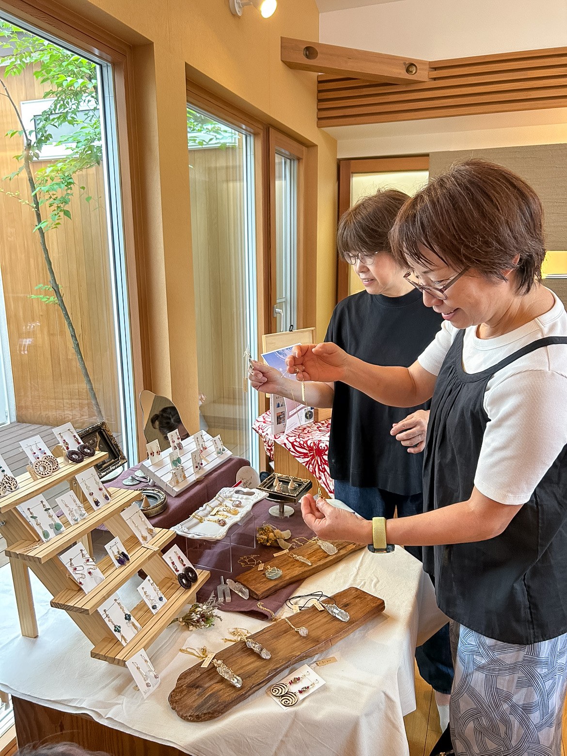 松戸店モデルハウスの室内に並んだハンドメイドアクセサリーを見ている来場者