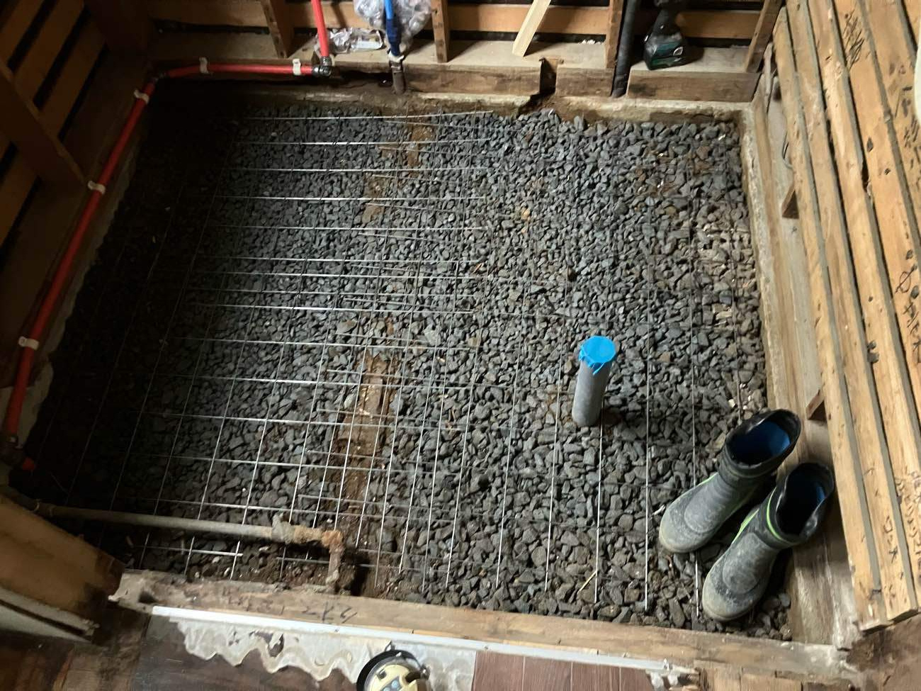 柏市I様邸の浴室リフォーム施工中。砕石の上にワイヤーメッシュを敷き並べた土間コンクリートの配筋作業