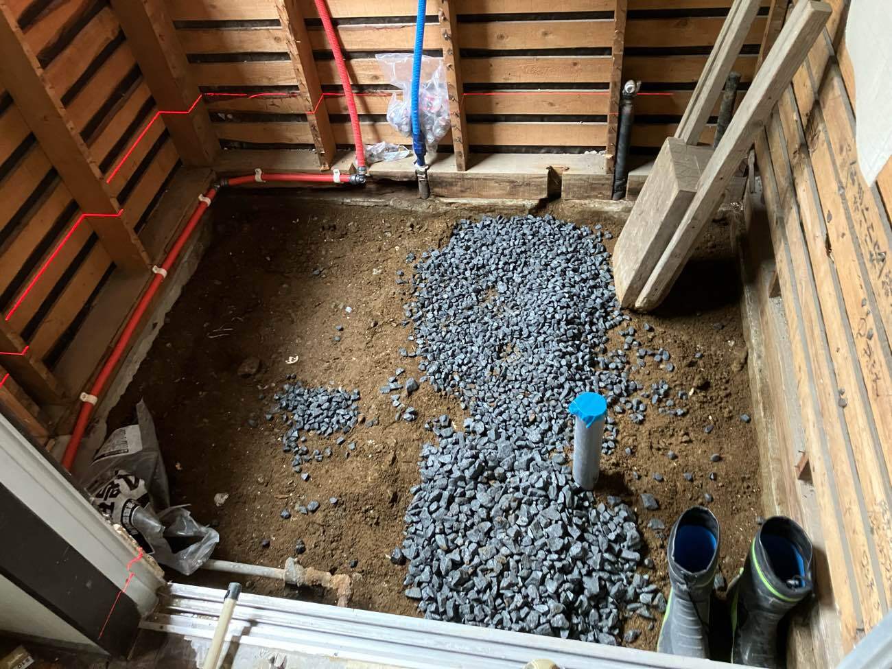 柏市I様邸の浴室リフォーム施工中。在来浴室を解体した床下に砕石を敷き込み、給排水の配管を立ち上げた状態