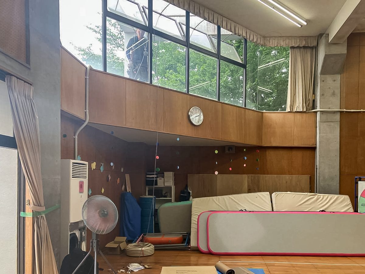 柏市晴山幼稚園の体育館全景。高窓のある天井の高い空間の壁際に床置形エアコンを設置