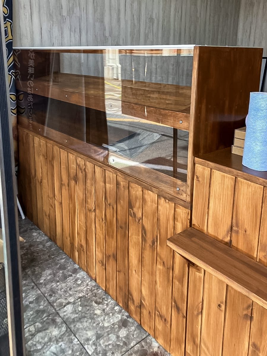 松戸市メロンLAB上本郷駅前店の工事中。塗装を終えた木製ショーケースを窓際に据え付けたところ
