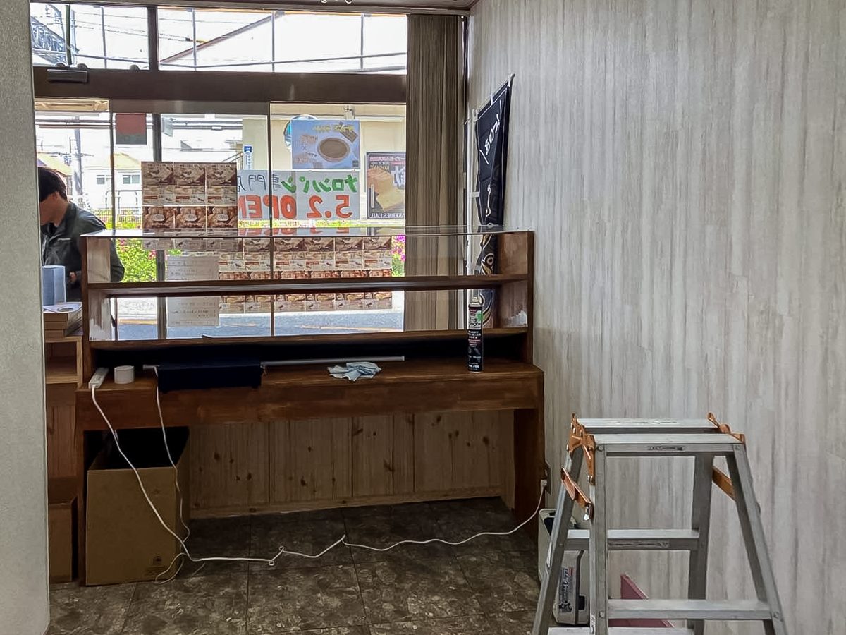 松戸市メロンLAB上本郷駅前店の工事中。窓際に設置したショーケースとレジカウンター、張り替えた壁紙